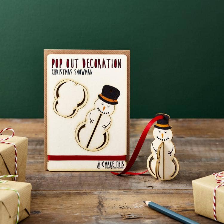 Pop Out Hanging Snowman Christmas Card with assembled wooden snowman decoration and red hanging ribbon in a festive setting