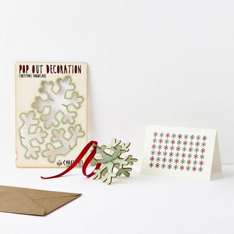 Pop Out Snowflake Christmas Card showing the pop-out sheet, assembled wooden snowflake, red ribbon and patterned greeting card