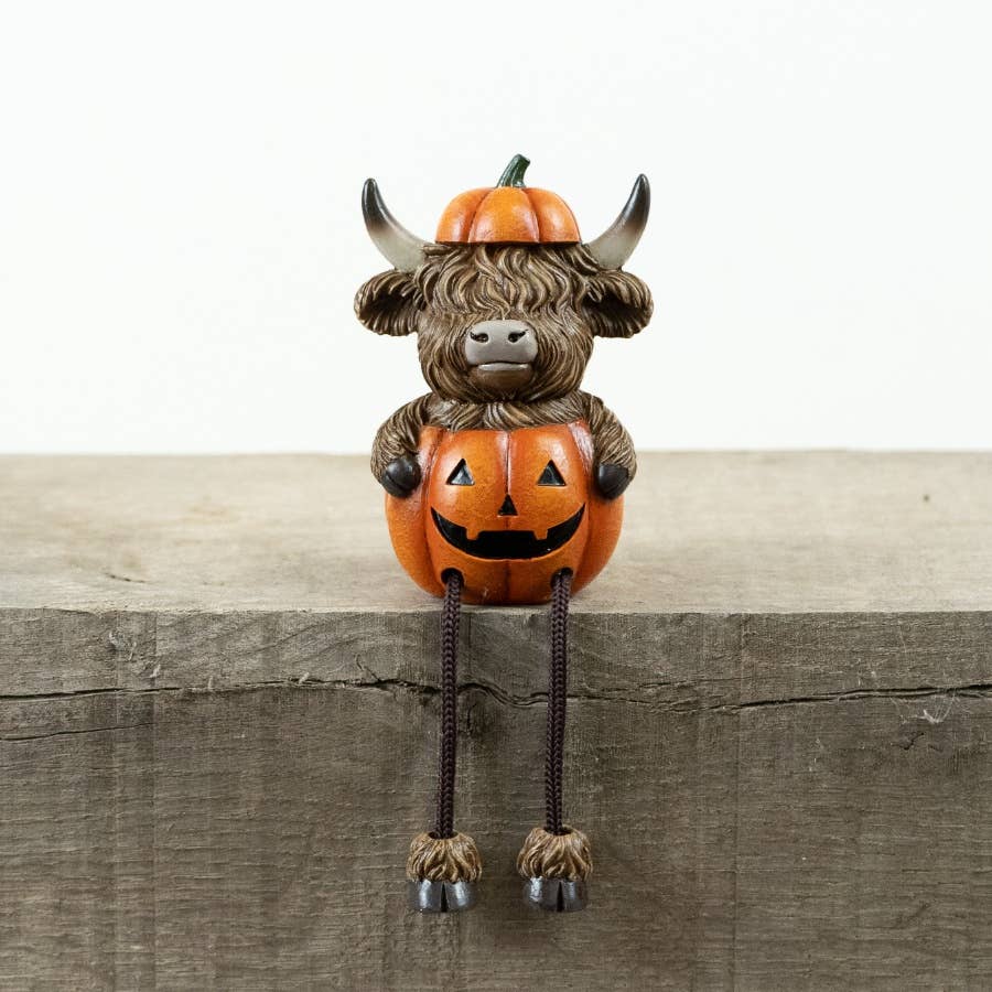 Pumpkin Highland Cow Shelf Sitter 10.5cm with orange jack-o'-lantern pumpkin and dangling legs
