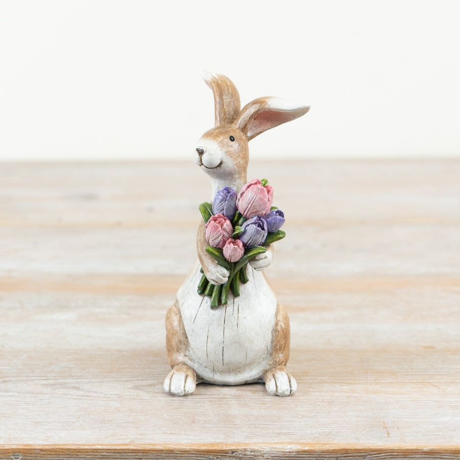 14cm brown rabbit ornament holding a bouquet of pink and purple flowers