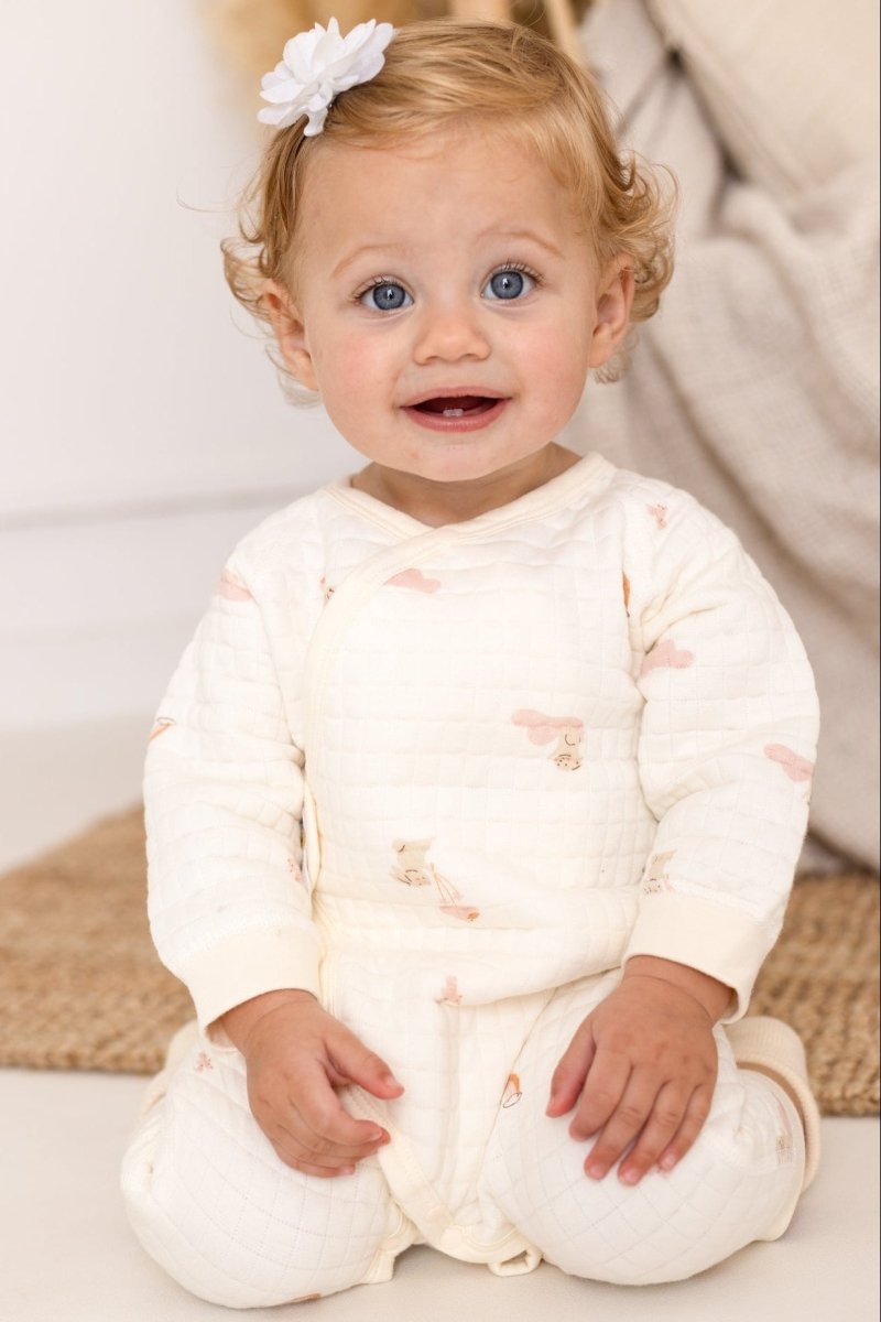 Front view of baby wearing the Rainbow Bouclé Wrap Baby Grow Romper