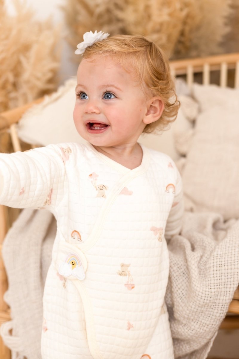 Baby wearing the soft Rainbow Bouclé Wrap Baby Grow Romper