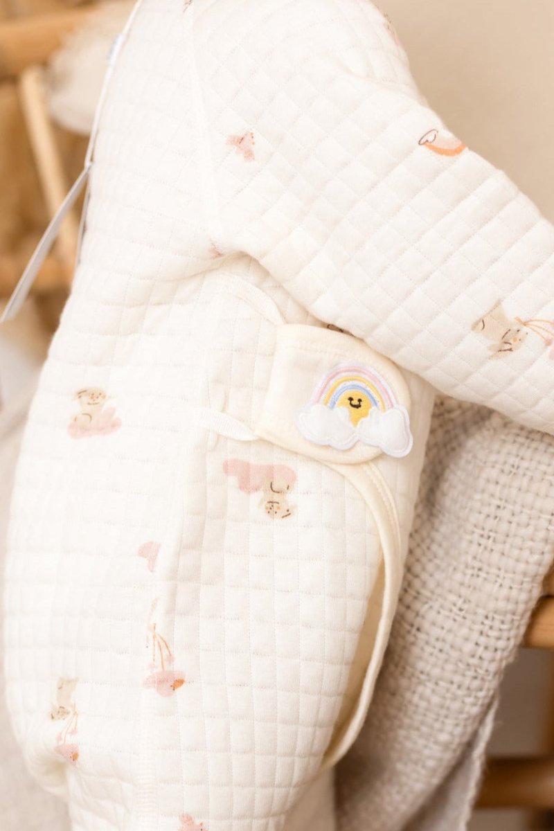 Close-up of the playful rainbow print on the Cozy Crew Club baby grow romper