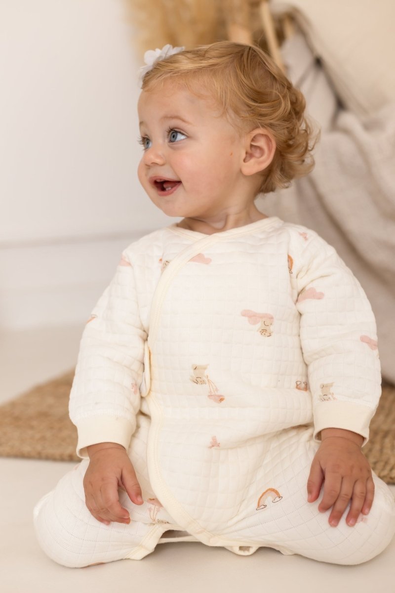 Baby wearing The Rainbow Bouclé Wrap Baby Grow Romper by Cozy Crew Club