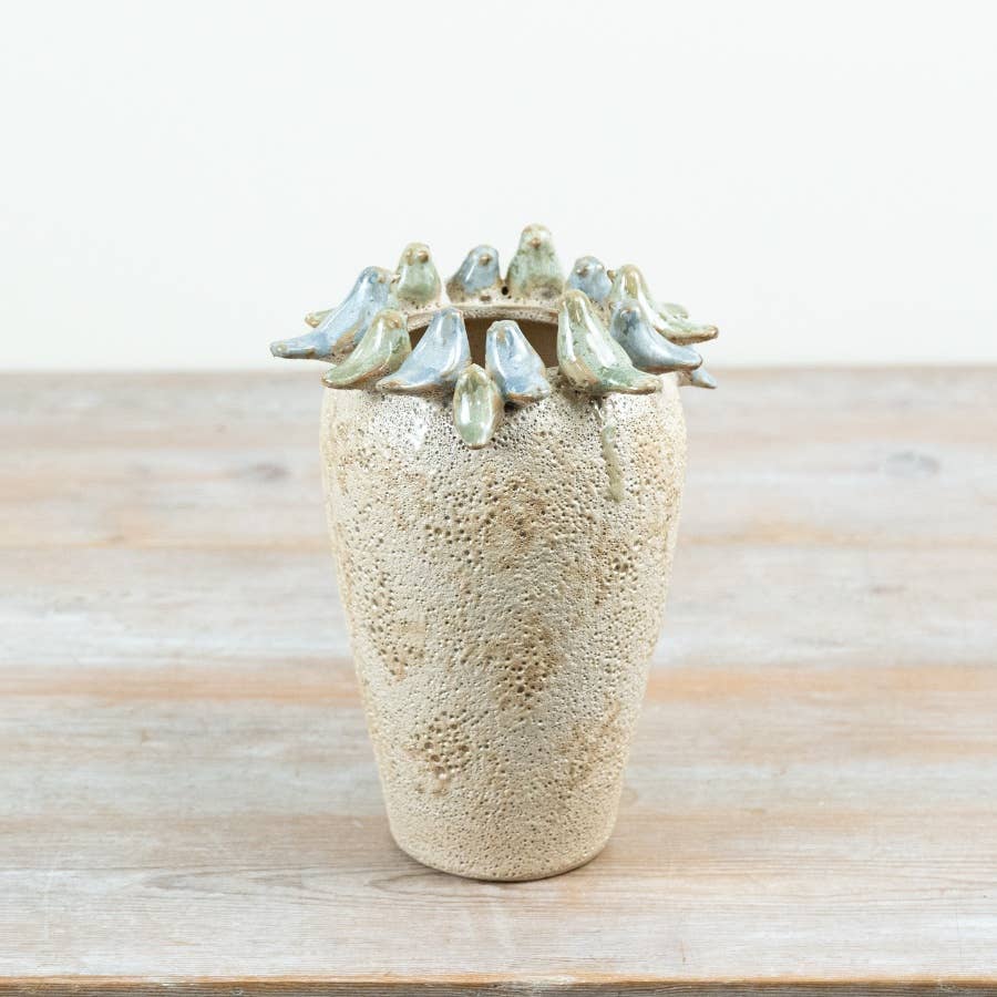 Stone Bird Vase 22cm with textured beige stone-effect finish and small blue-green glazed birds perched around the rim, displayed on a wooden table.