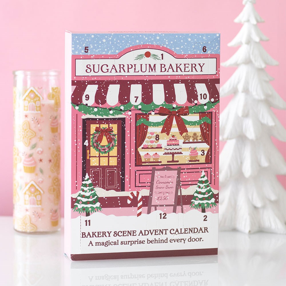 12-Day Sugarplum Bakery advent calendar displayed beside a white Christmas tree and festive candle