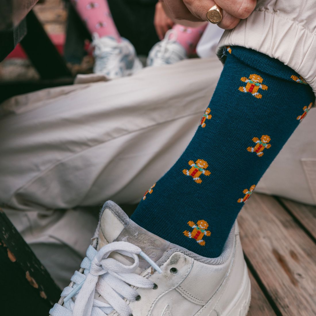 Adult wearing navy Swole Panda Gingerbread Men bamboo socks with orange details