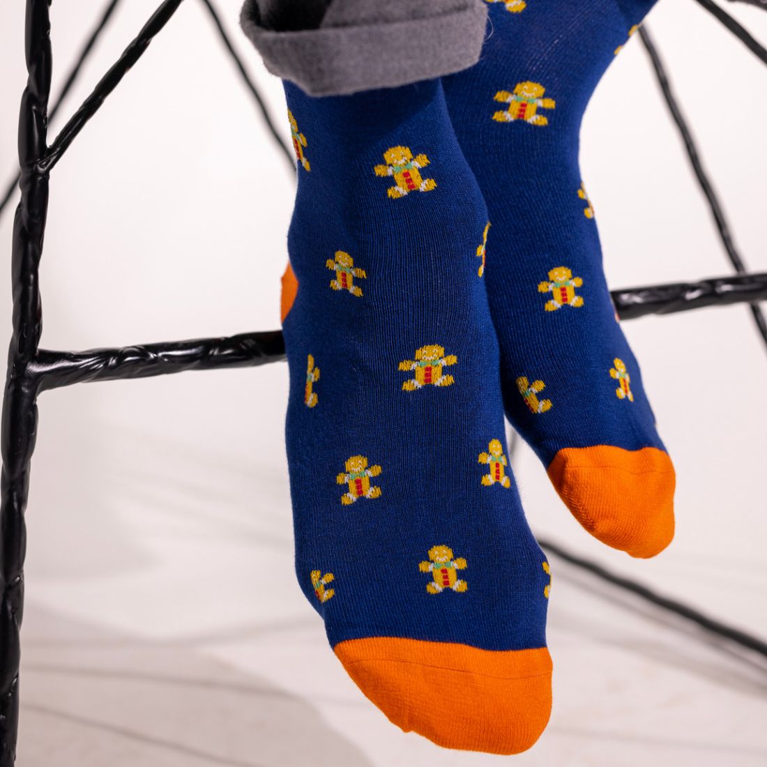 Child wearing navy Swole Panda Gingerbread Men bamboo socks with orange heel and toe
