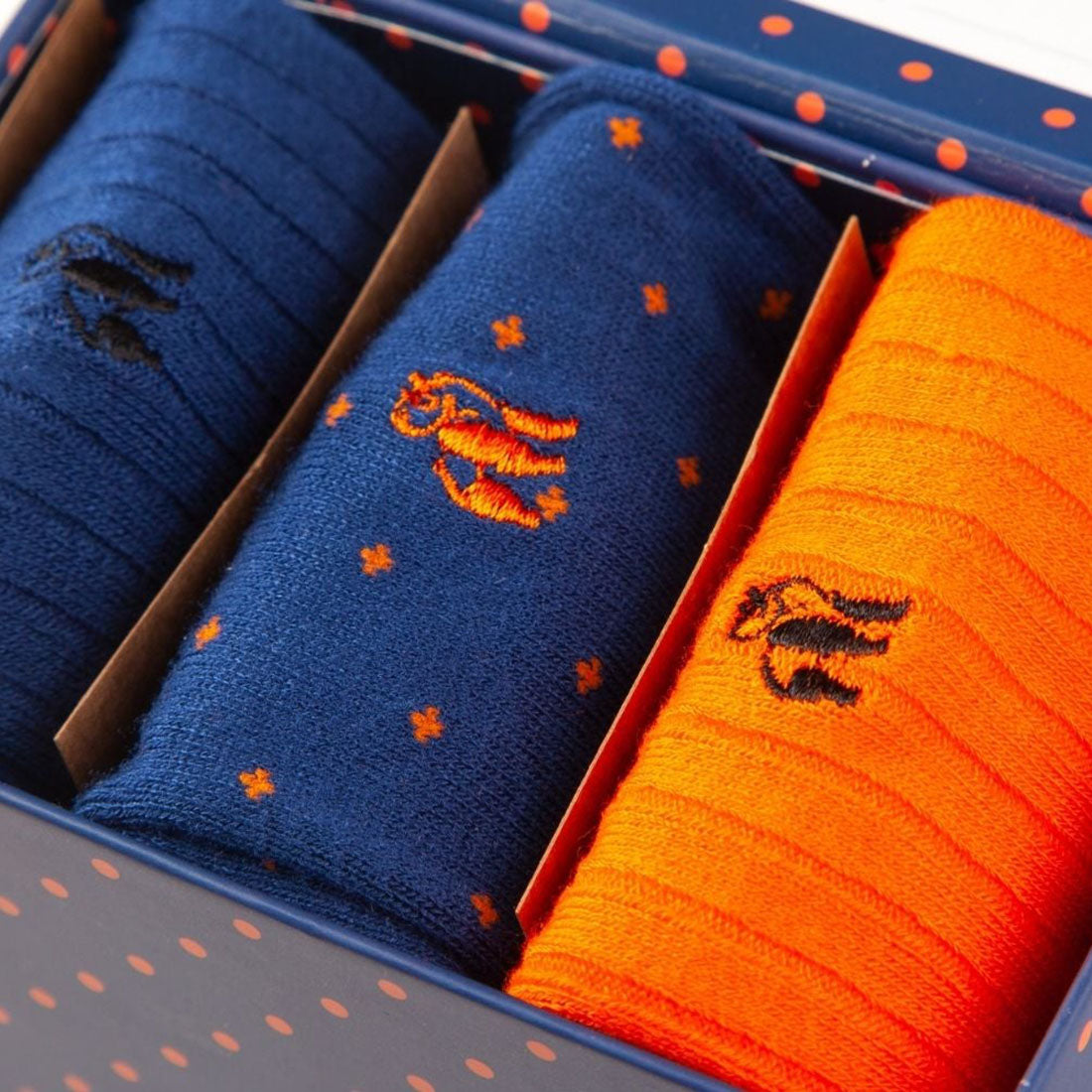 Close-up of orange and blue Swole Panda bamboo socks presented inside the gift box