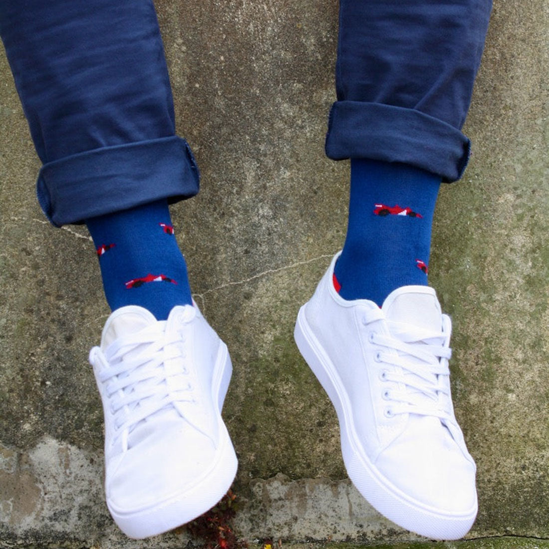 Child wearing navy Swole Panda Racing Cars bamboo socks with red details