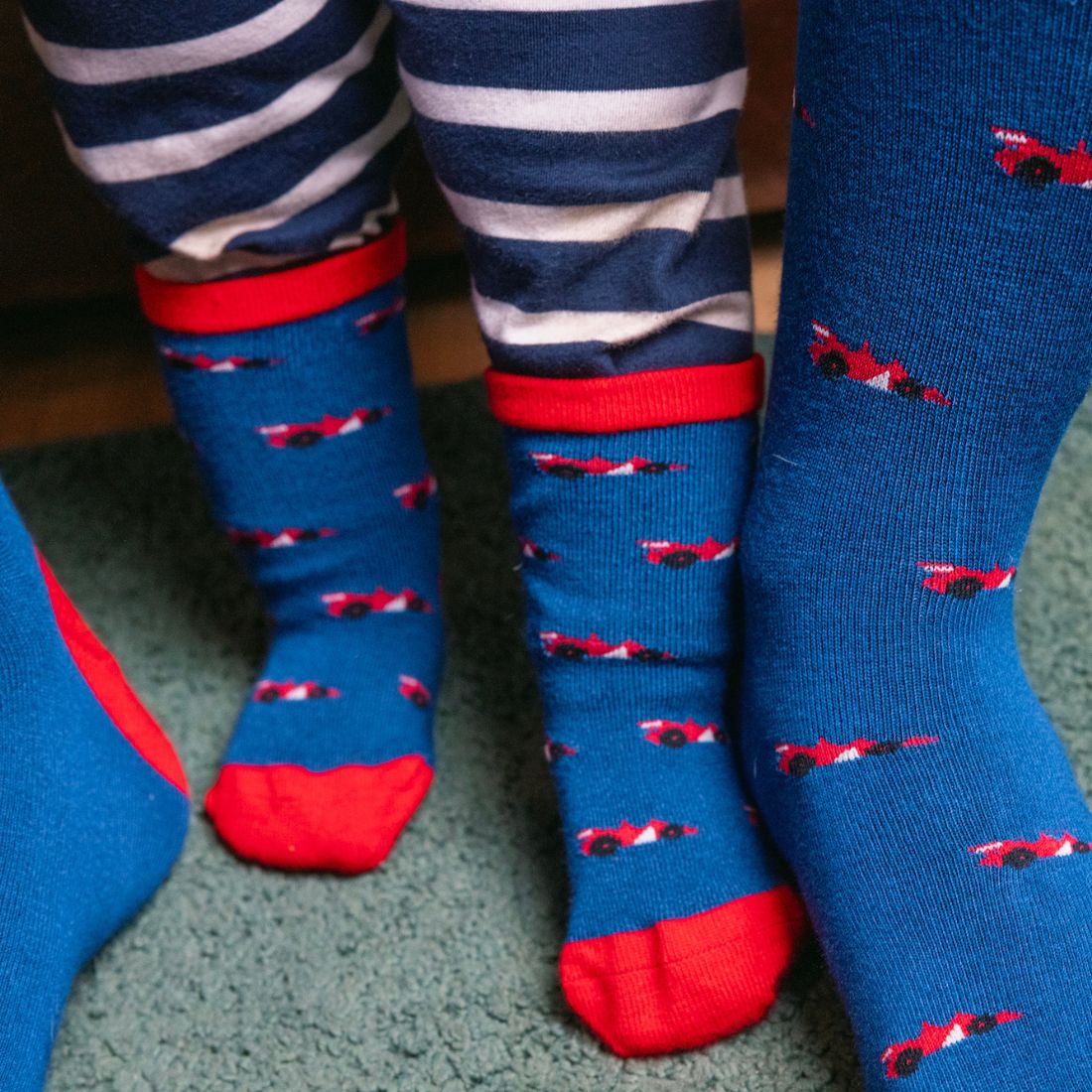 Adult and child wearing matching Swole Panda Racing Cars bamboo socks