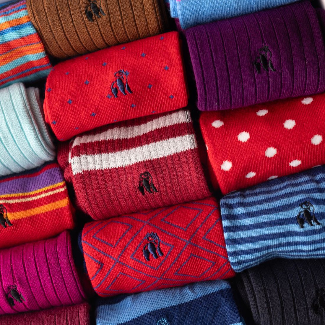 Close-up of red and purple Swole Panda bamboo socks with assorted patterned designs