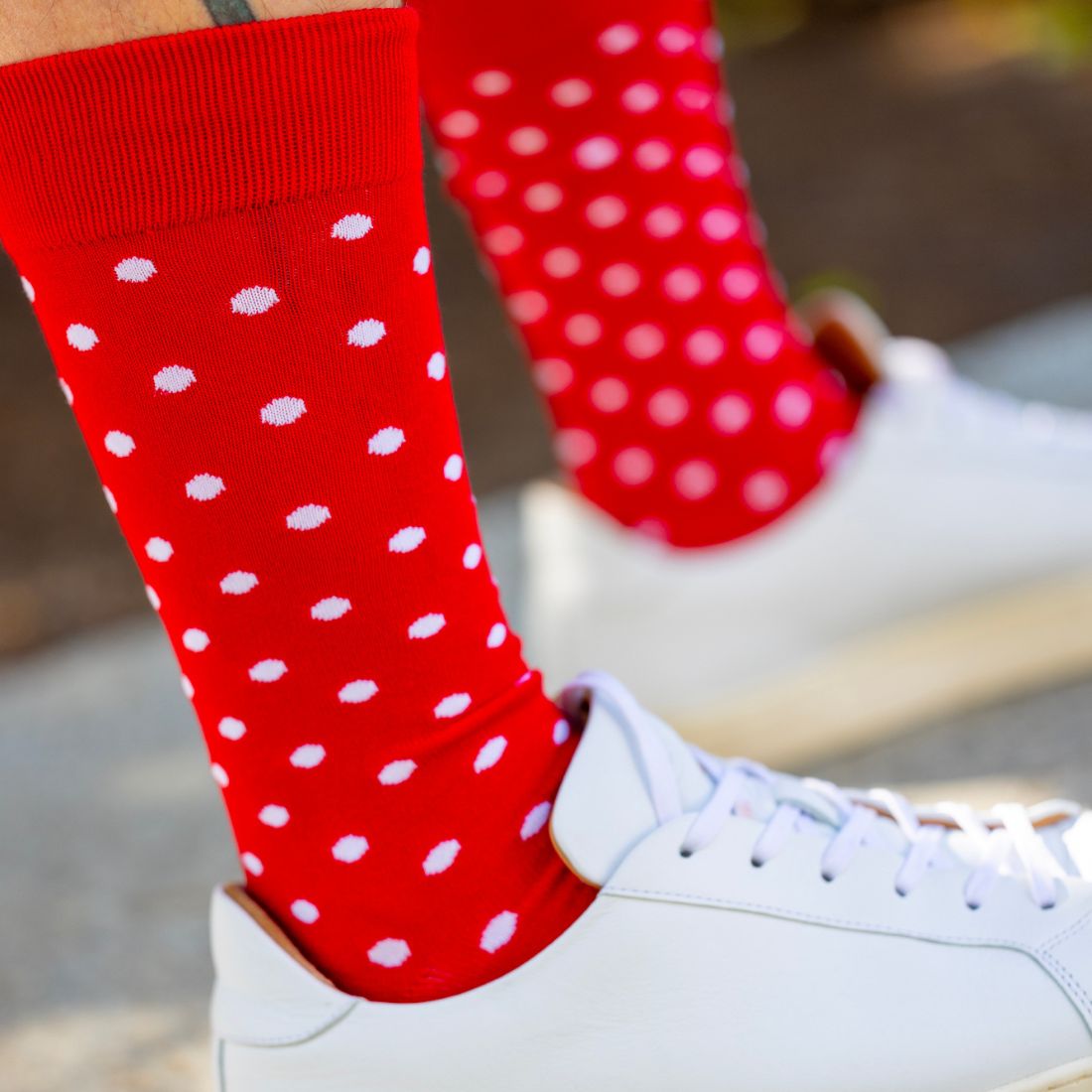 Red Swole Panda bamboo socks with white spot pattern worn with white trainers