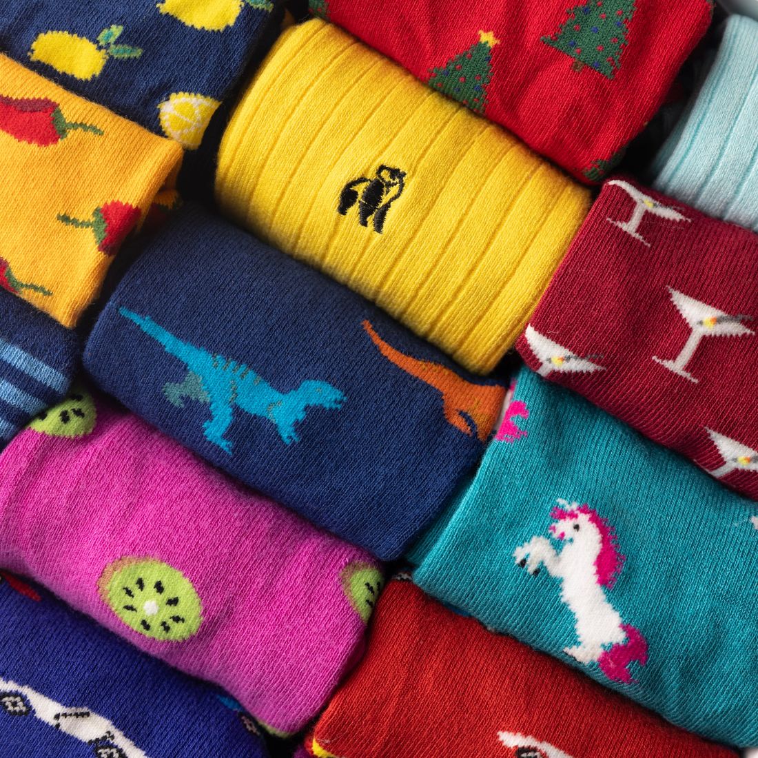 Close-up of yellow, red and blue Swole Panda bamboo socks with assorted colourful patterns