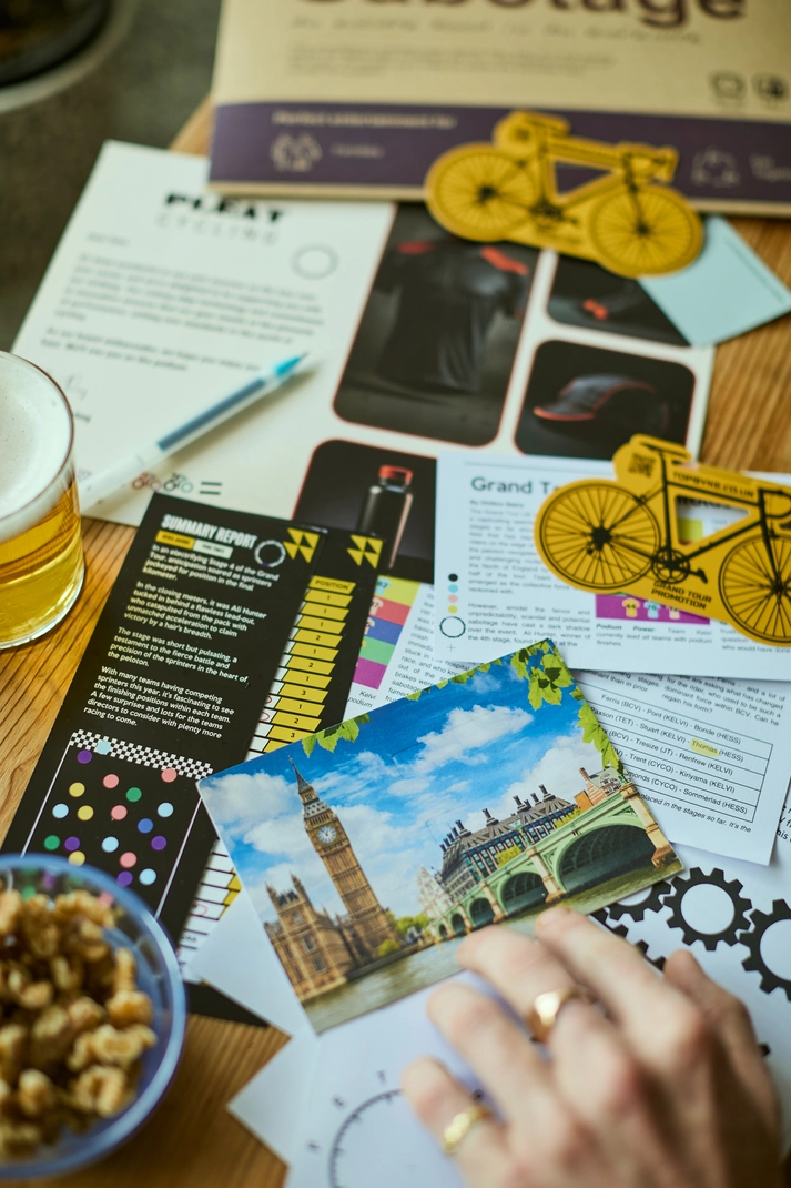 The Sabotage puzzle game in play with immersive cycling clues and documents spread across a table