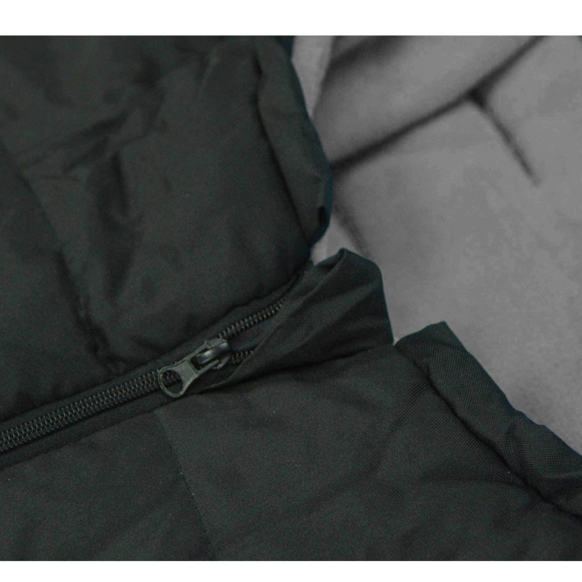 Close-up of a dark green footmuff with a zipper, showing fabric texture.