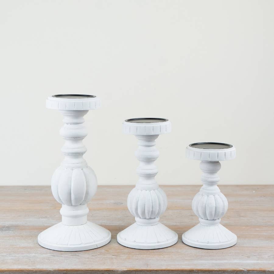 Whitewash turned candle holders displayed together in coordinating sizes