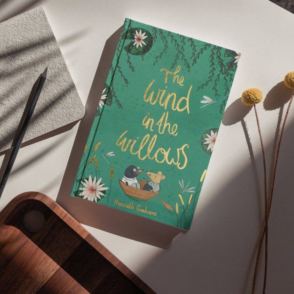Wind in the Willows Wordsworth Collector's Edition hardback by Kenneth Grahame displayed on a rustic writing desk.