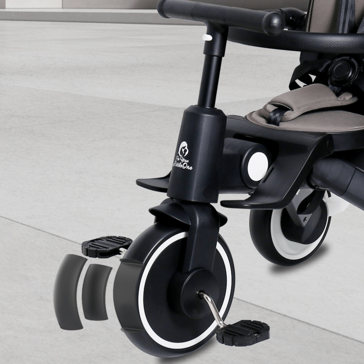 Xplor Ultimate 6 in 1 Foldable Trike in Jet Black close-up showing the front wheel and footrest area