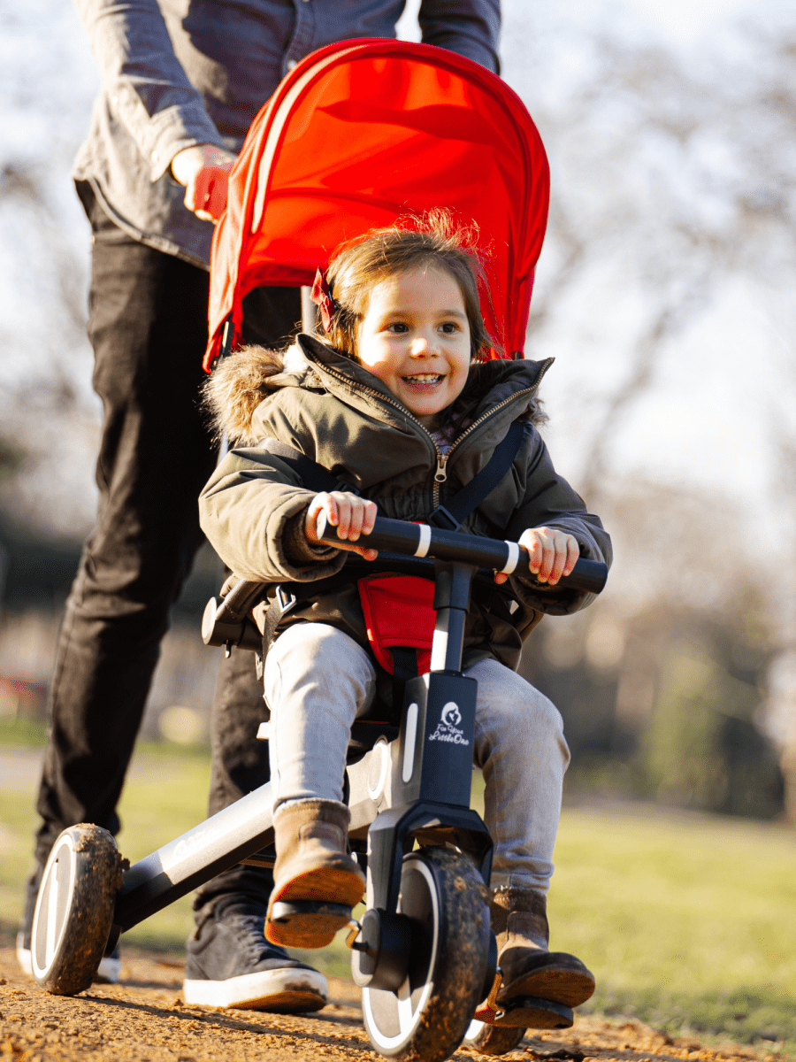 Xplor Ultimate 6 in 1 Foldable Trike in Jet Black being used by a young child outdoors